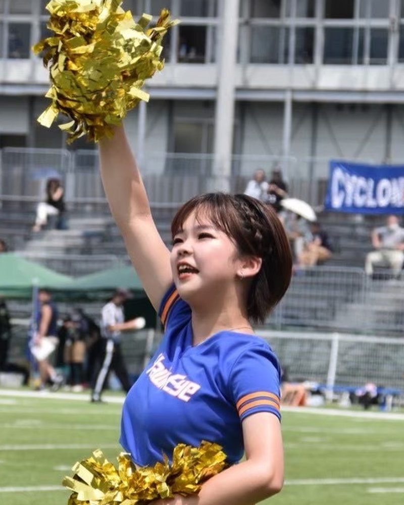 インストラクター 木村彩乃（あやの先生）がポンポンを掲げて応援する様子